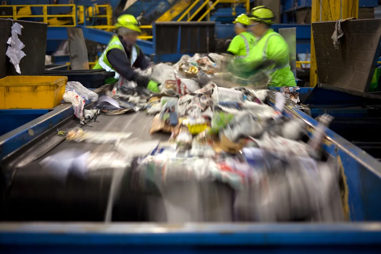 a photo of people organising waste at a commercial recycling facility in Neath, Port Talbot, And Swansea