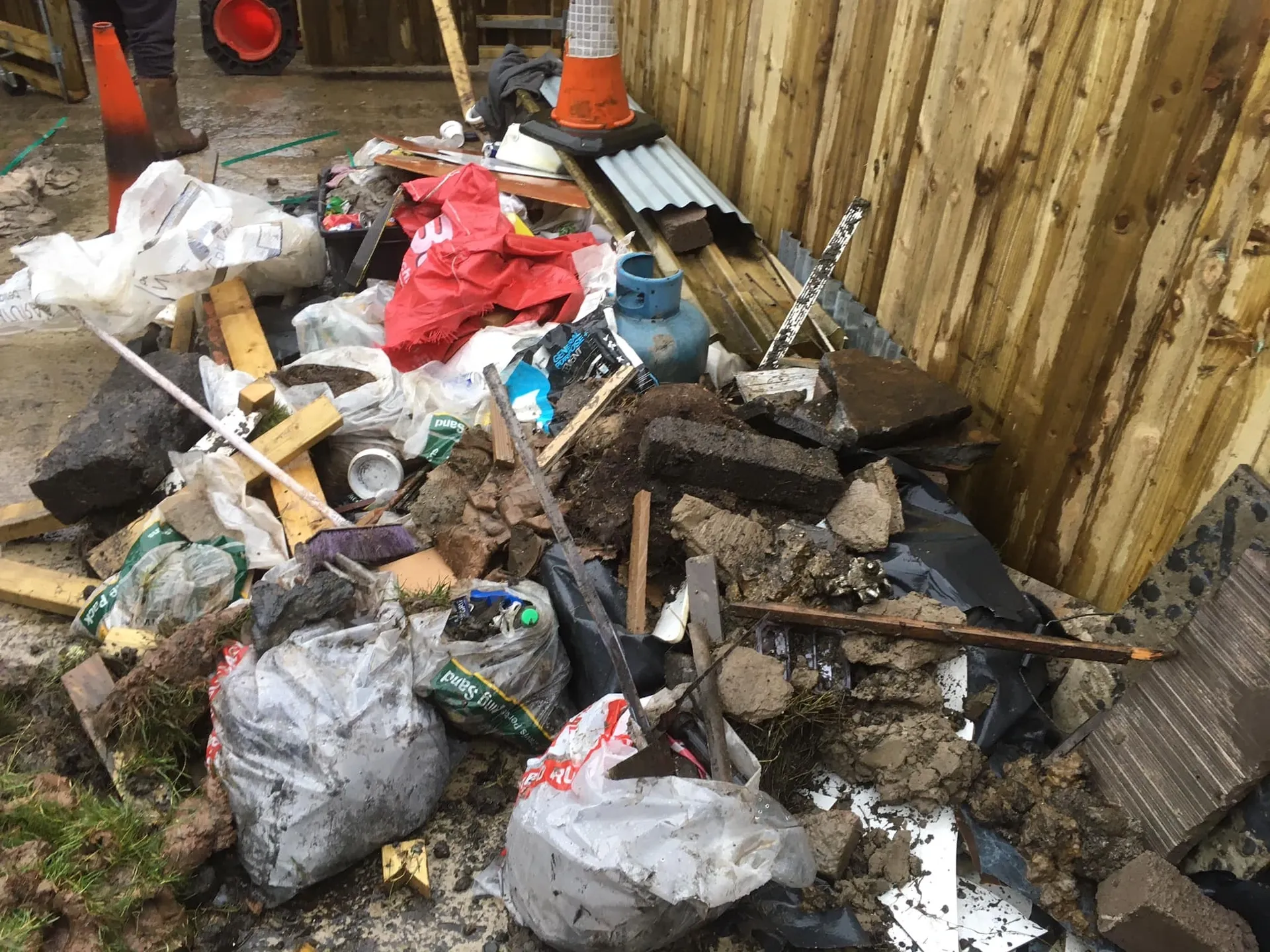a photo of junk by a wooden fence in Neath, Port Talbot, And Swansea