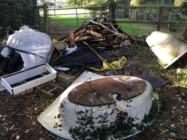 a photo of junk in a garden in front of a metal gate in Neath, Port Talbot, and Swansea