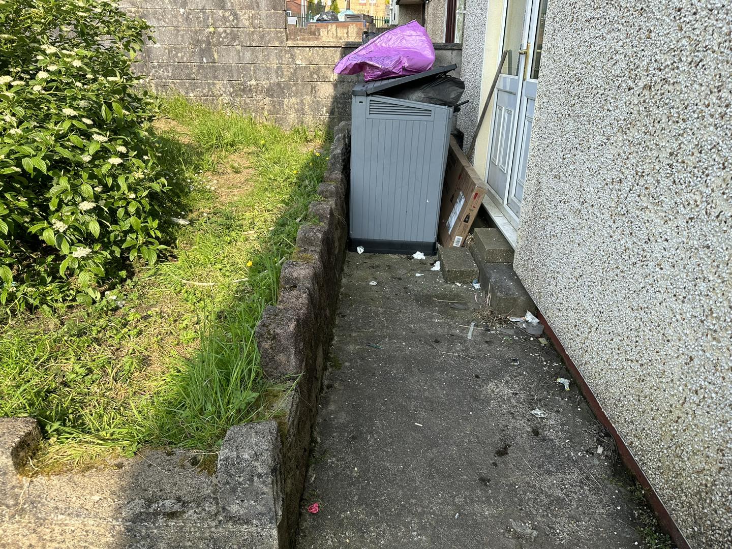 a photo of a pink recycling bag by a garden in Neath, Port Talbot, And Swansea