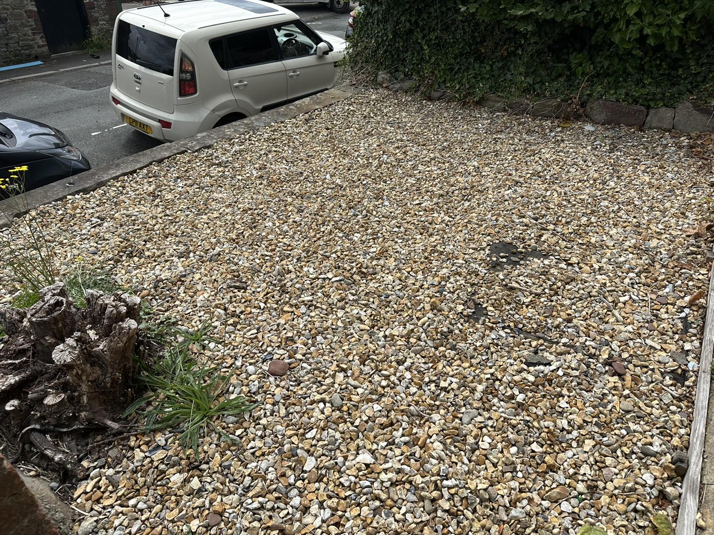 a photo of a white car next to gravel garden in Neath, Port Talbot, And Swansea