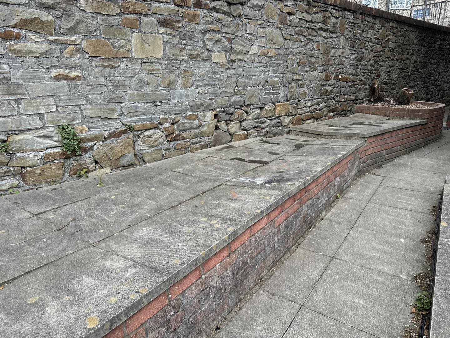 a photo of a brick wall next to concrete pathway in Neath, Port Talbot, And Swansea