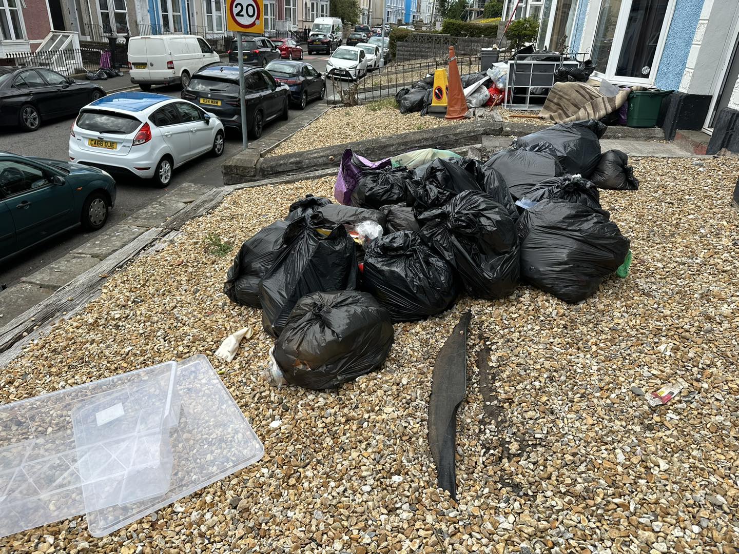 a photo of black bags on gravel garden next to parked cars in Neath, Port Talbot, And Swansea