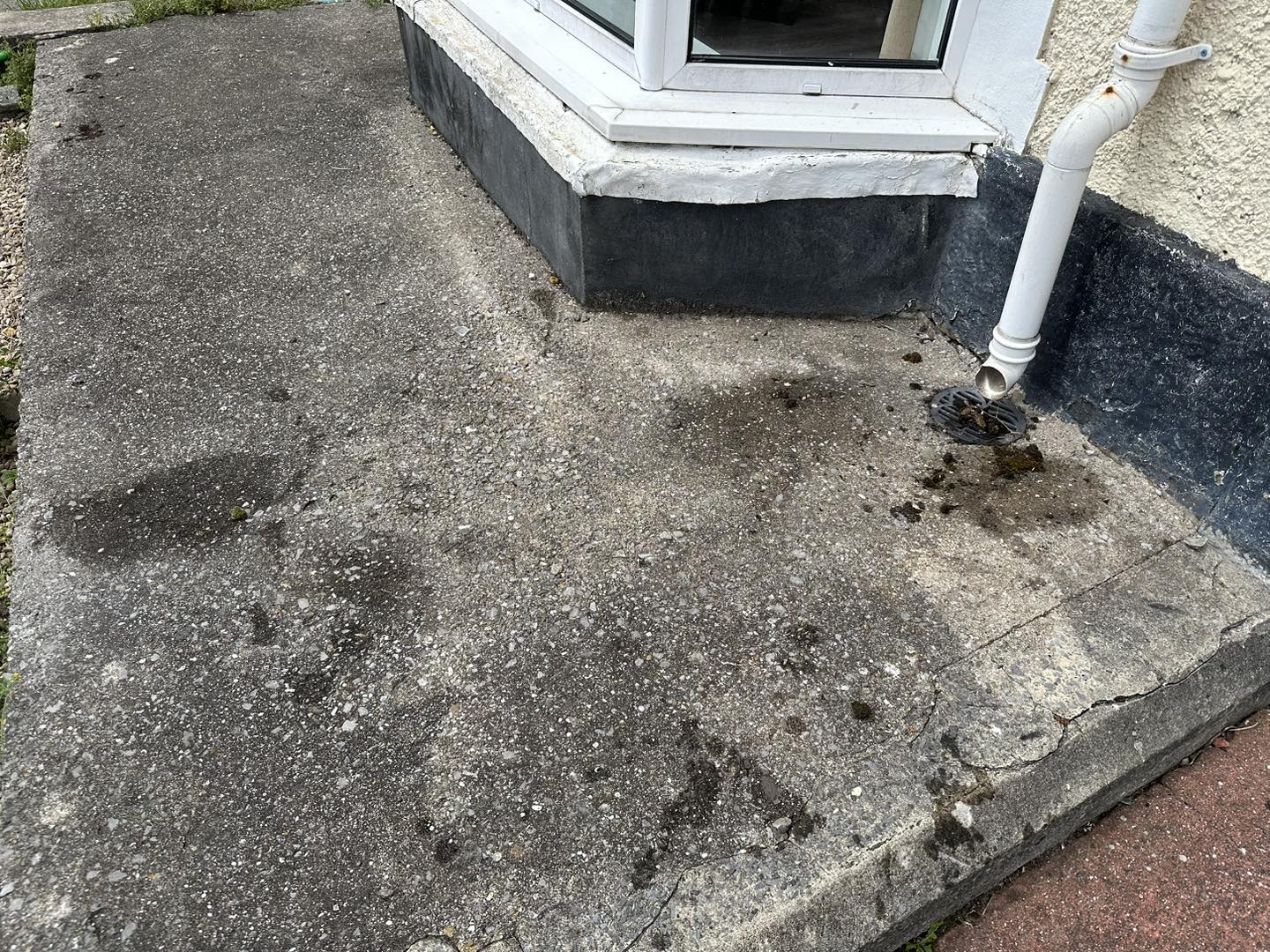 a photo of a window frame and downpipe on concrete floor in Neath, Port Talbot, And Swansea
