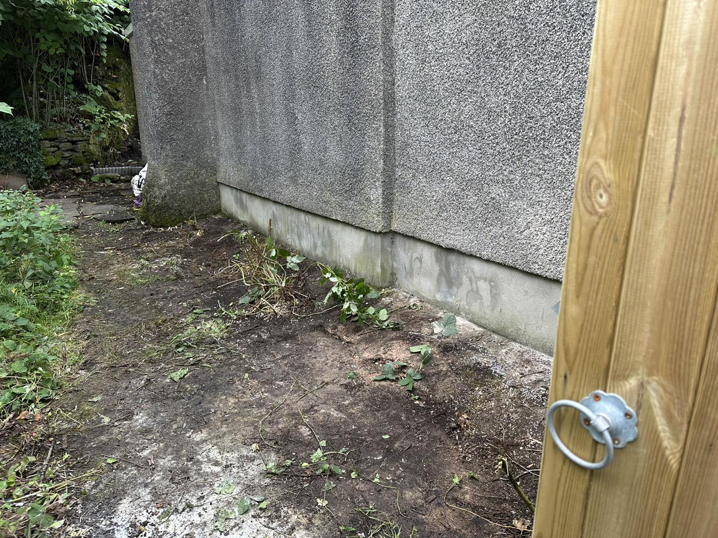 a photo of a concrete wall with a wooden gate along the side in Neath, Port Talbot, And Swansea