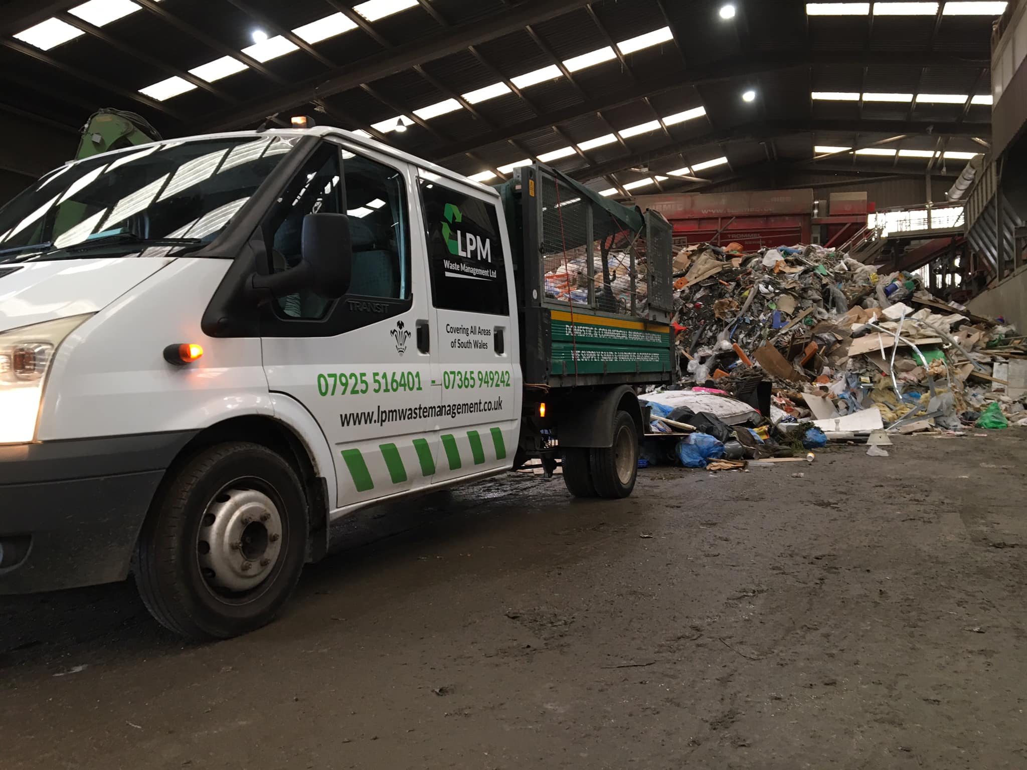 A photo of a waste truck in a commercial recycling plant