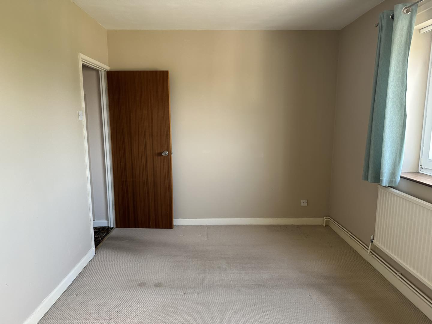 A photo of a clean empty bedroom in a house