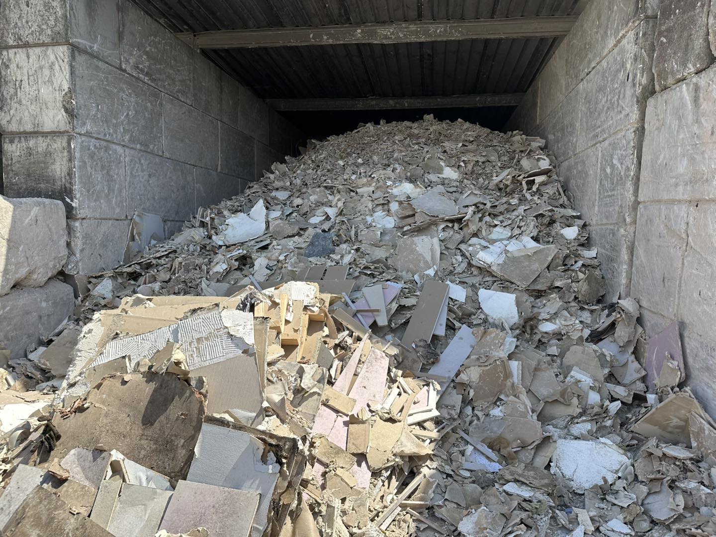 Plasterboard waste inside a concrete storage bay.